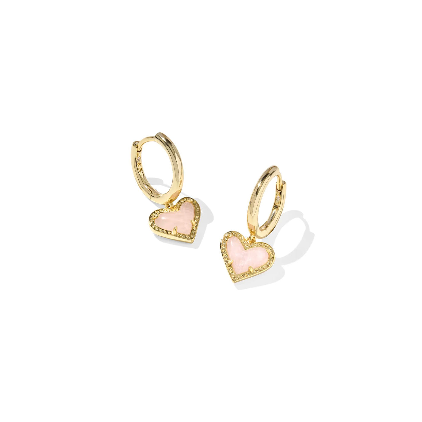 Gold hoop earrings with pink heart charms on a white background