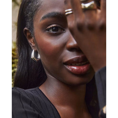 person wearing silver hoop earrings