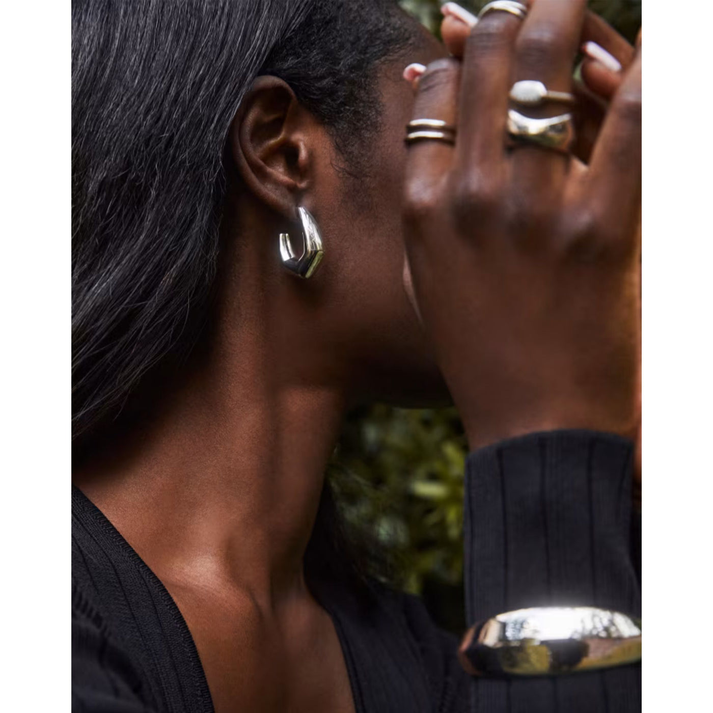 person wearing silver hoop earrings, side shot